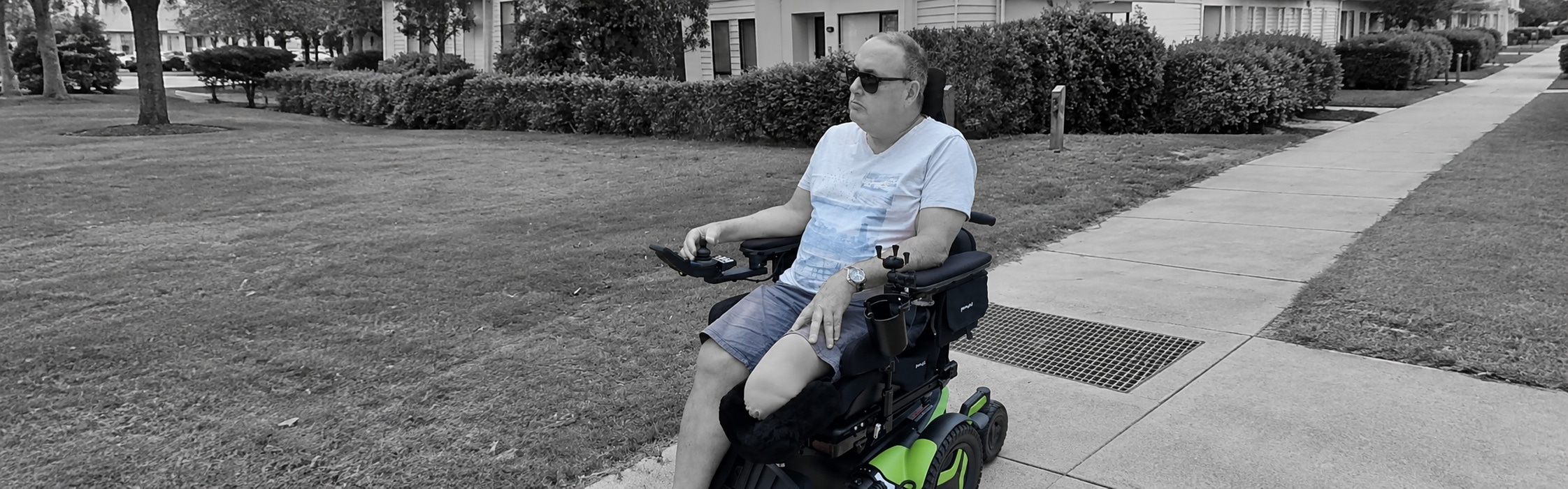NDIS participant living with physical disability using a powered wheelchair outdoors, supported by Global Rehabilitation Service